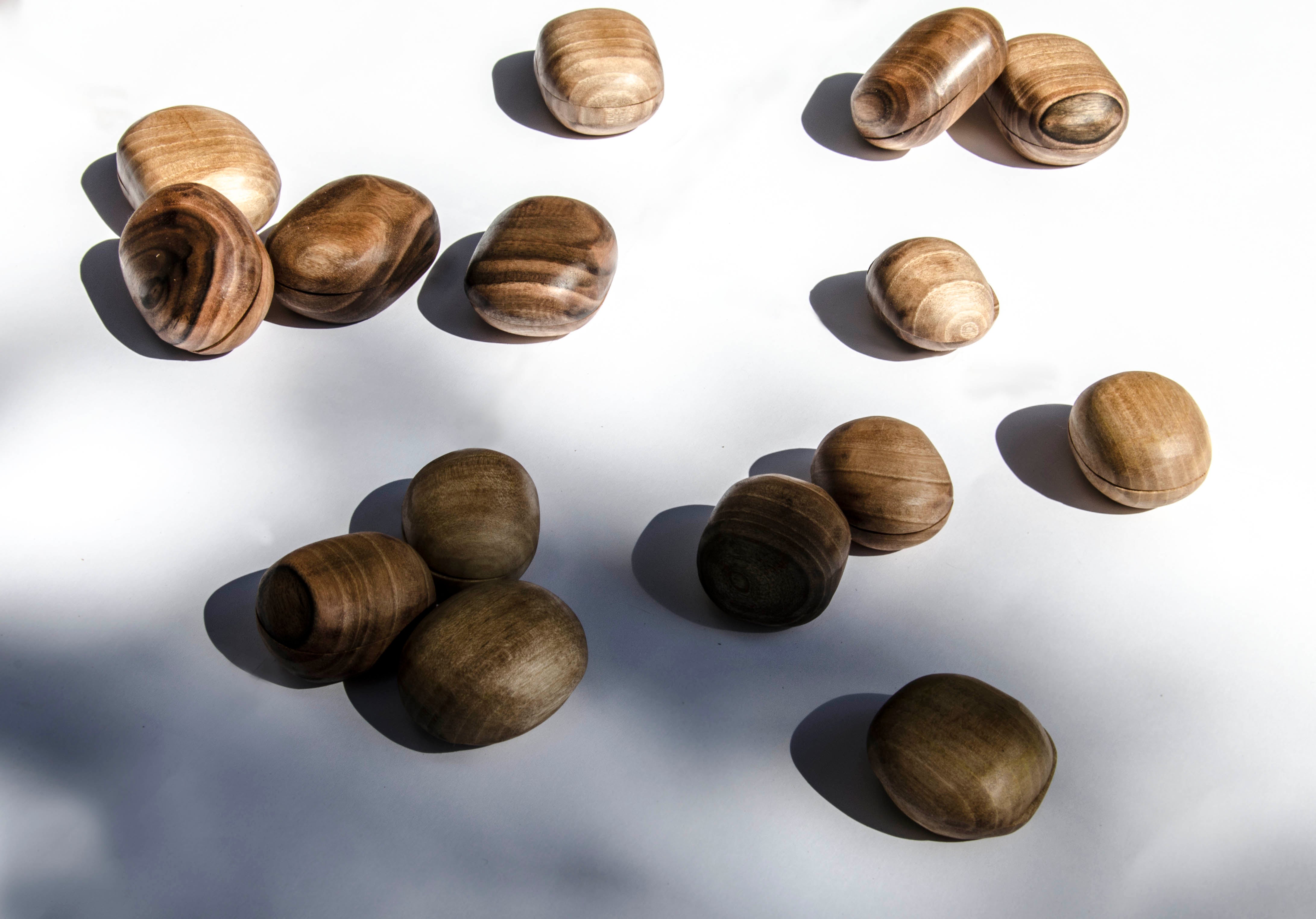 oval hand-carved irregular small walnut wood jewelry boxes on a white background